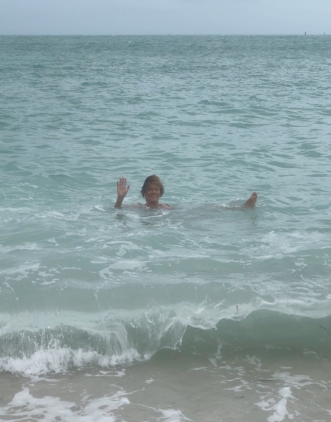 Rosalind Brackenbury waving from the sea while wild swimming at Fort Zachary Taylor in Key West